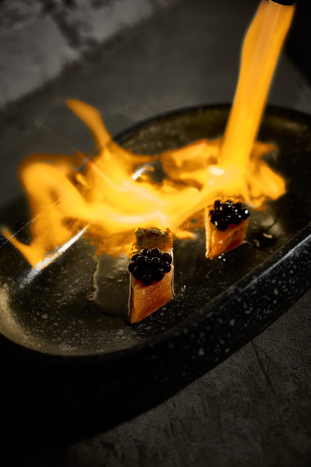 A dish finished in flame at the table